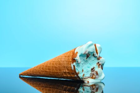 salted caramel flavor ice cream cone with a bite on a glass with reflectionの写真素材