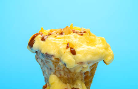 blueberry and cheese flavor ice cream cone melts a lot on blue backgroundの写真素材