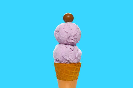 fresh sweet potato ice cream cone with a chocolate candy on blue backgroud