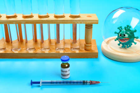covid-19 vaccine and syringe and a coronavirus model on background horizontal composition