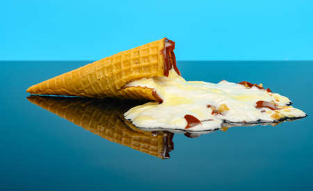 melted vanilla flavor ice cream cone on a glass with reflectionの写真素材