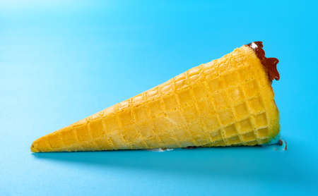 side view empty ice cream cone on a blue backgroundの写真素材
