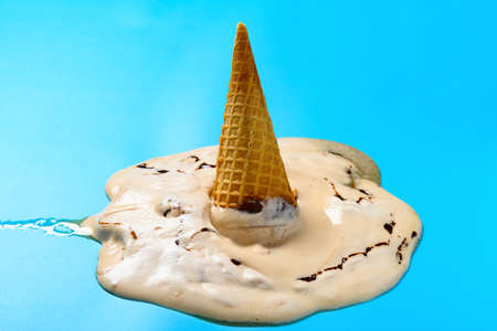 side view melted milk tea flavor ice cream cone on a blue background