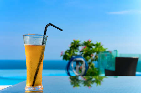 cup of fresh cold drink with an ocean at the far endの写真素材