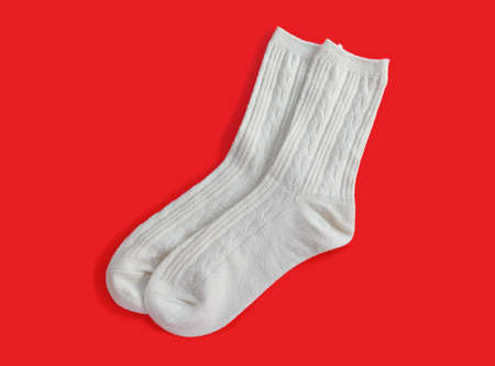 pair of grey socks for lady on red background