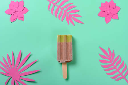 fresh red bean and green tea flavor ice pop with paper cutting flowers and leaves on green backgroundの写真素材