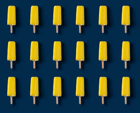 seamless yellow ice pop on a dark blue backgroundの写真素材