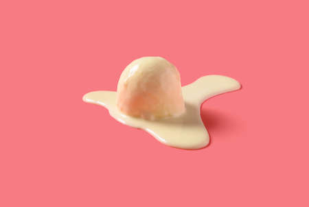 side view vanilla flavor ice cream ball in a melting process on pink backgroundの写真素材