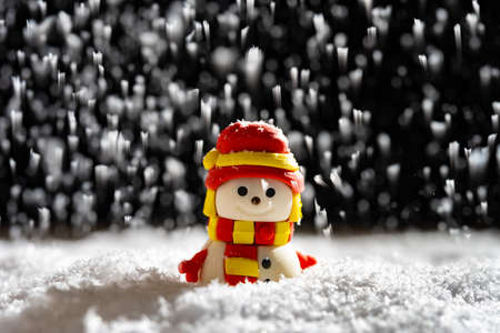 smiling snowman in a snowing nightの写真素材