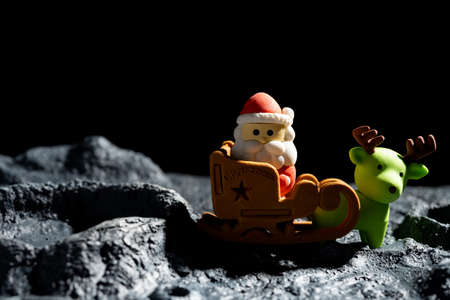 cute santa claus on sled and reindeer on a planet with cratersの写真素材
