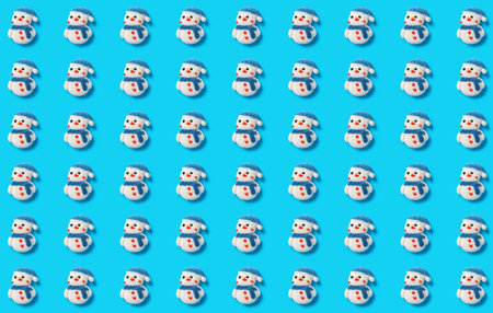 pattern of cute snowman candies on a blue backgroundの写真素材