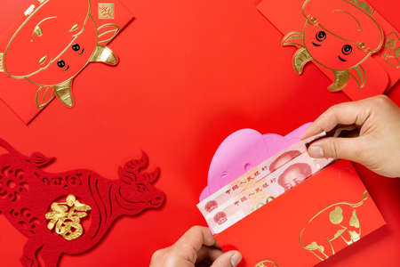 man preparing a red pocket with Chinese currency for the year Oxの写真素材