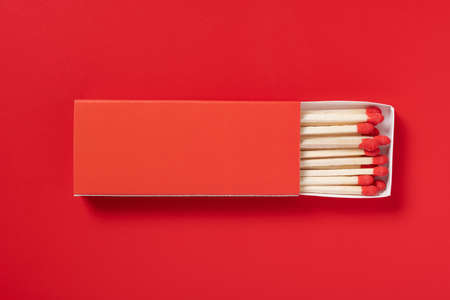 red matchbox and red match sticks on a red background