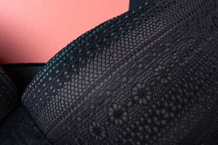 part of a black bra for women close up on pink backgroundの写真素材