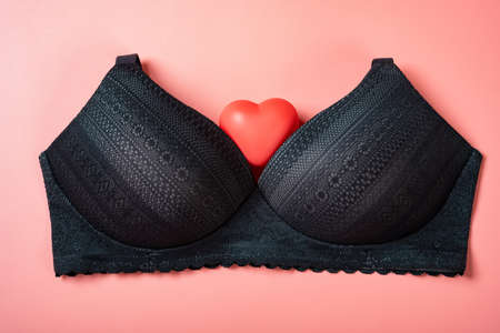 black color bra for women with a heart on a pink backgroundの写真素材