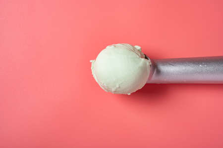 top view spoon with fresh hami melon flavor ice cream on a pink backgroundの写真素材