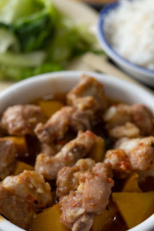 angle view Chinese food of steamed pork ribs with pumpkin and cabbage and bowl of rice vertical compositionの写真素材