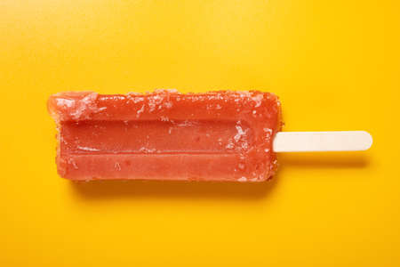 top view fresh red ice cream stick on a yellow backgroundの写真素材