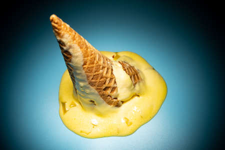 high angle view melted ice cream cone highlighted in darkの写真素材