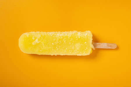 fresh yellow ice pop on a yellow backgroundの写真素材