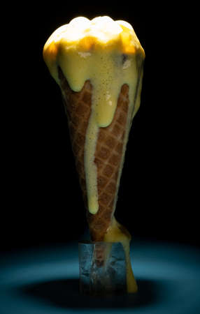 melting ice cream cone highlighted in darkの写真素材