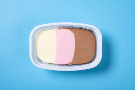 cup of multicolor ice cream on blue background