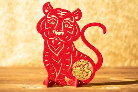 Chinese New Year of tiger 2022 mascot paper cut on a wood table in the morning the Chinese means fortuneの写真素材