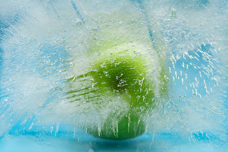 green apple in a frozen ice blockの写真素材