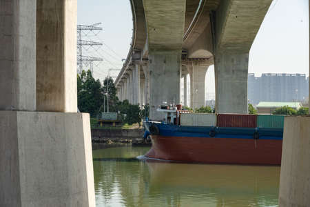 vessel with containers passing a bridgeの写真素材
