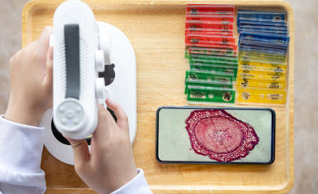 kid using an electrical microscope and seeing the enlarge photo on a mobileの写真素材
