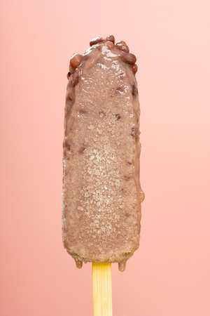 red bean ice cream stick melting on a pink background