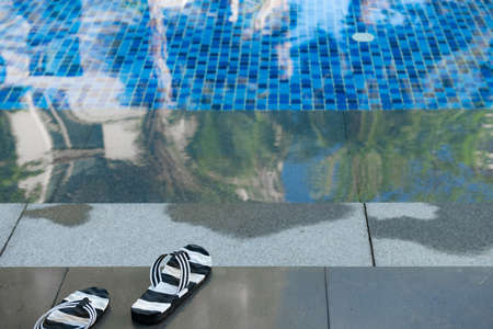 angle view swimming pool and pair of slippers