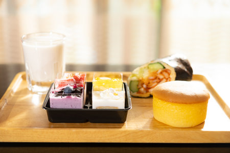 fresh sweet cakes and seaweed roll and cup of milk in a sunny morning