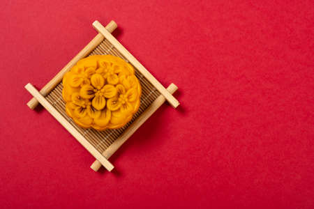 trendy flower shape mooncake on red background with copy spaceの写真素材