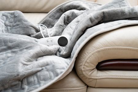 electric blanket with controller on a sofaの写真素材