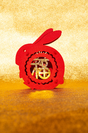 Chinese New Year of Rabbit mascot paper cut on golden background at vertical composition translation of the Chinese word is fortune no logo no trademarkの写真素材