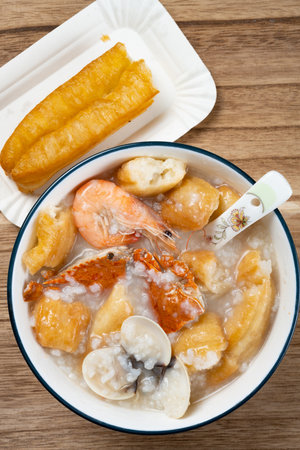 top view seafood porridge with crabs and shrimps and white shells and deep-fried dough sticksの写真素材