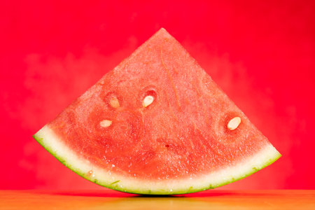 piece of fresh watermelon on red at horizontal composition