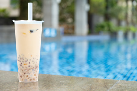cup of grass jelly near a swimming pool at horizontal compositionの写真素材