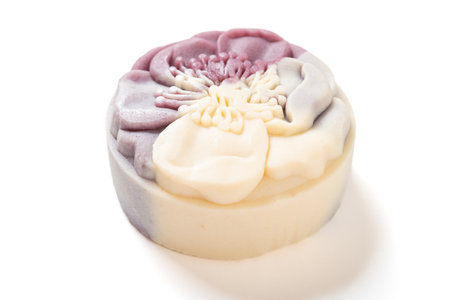 angle view trendy and beautiful flower shape purple and white colors moon cake on a white backgroundの写真素材