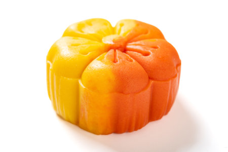 angle view trendy and beautiful flower shape yellow and orange colors moon cake on a white...