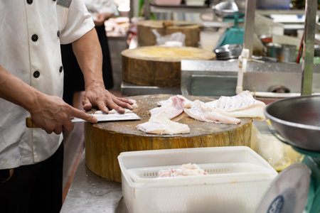 chief cutting fish in a kitchen
