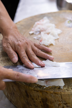 chef cutting fish in a kitchen at vertical compositionの写真素材