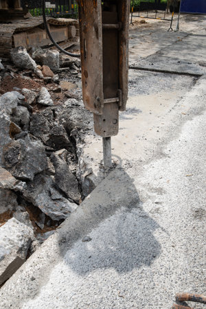 a drilling machine breaks up the concrete floor at vertical composition