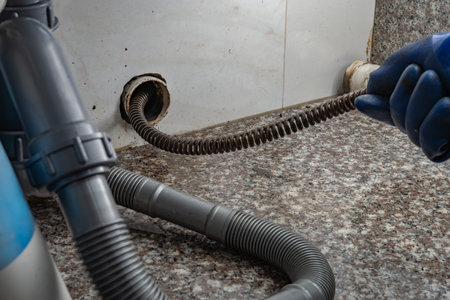 plumber using equipment to remove grease from the drain pipeの写真素材