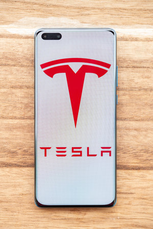 ZHONGSHAN China-November 8,2023:a mobile with Tesla logo at vertical composition.