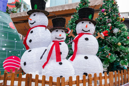 three snowmen and fir-trees at horizontal compositionの写真素材