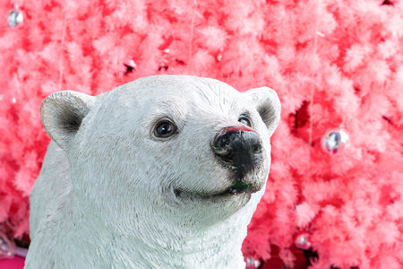 a polar bear in front of a giant size pink Christmas tree at horizontal compositionの写真素材