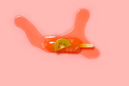 peach and oolong flavor with a slice of kiwi fruit ice pop in a melting process on a pink backgroundの写真素材