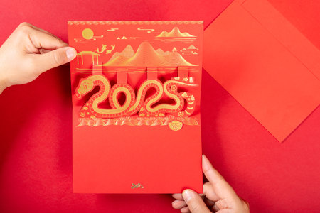 man holding a 3D gift card of a snake on white background at horizontal compositionの写真素材